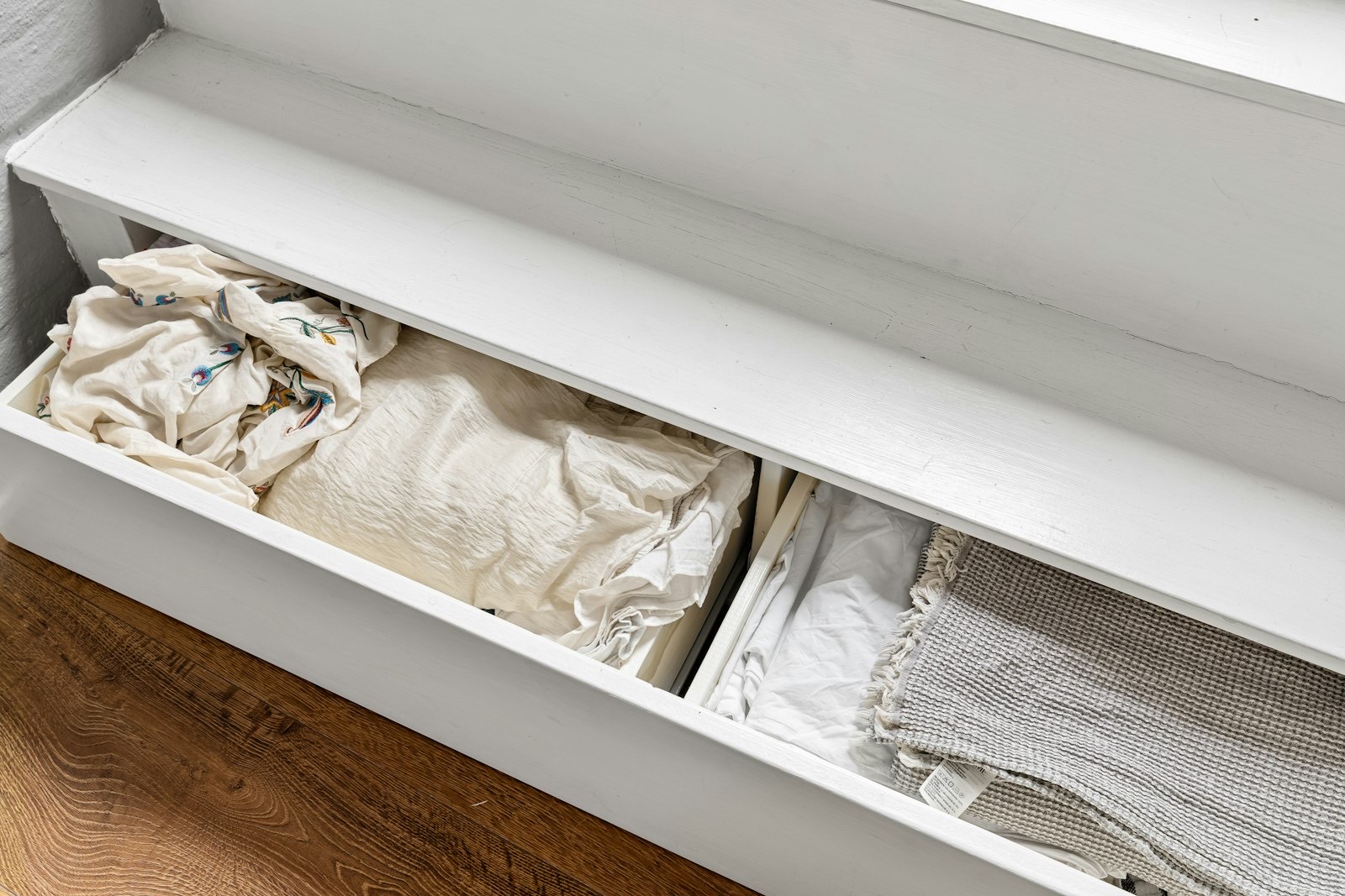 Open dresser drawer with folded clothes showing usable storage depth