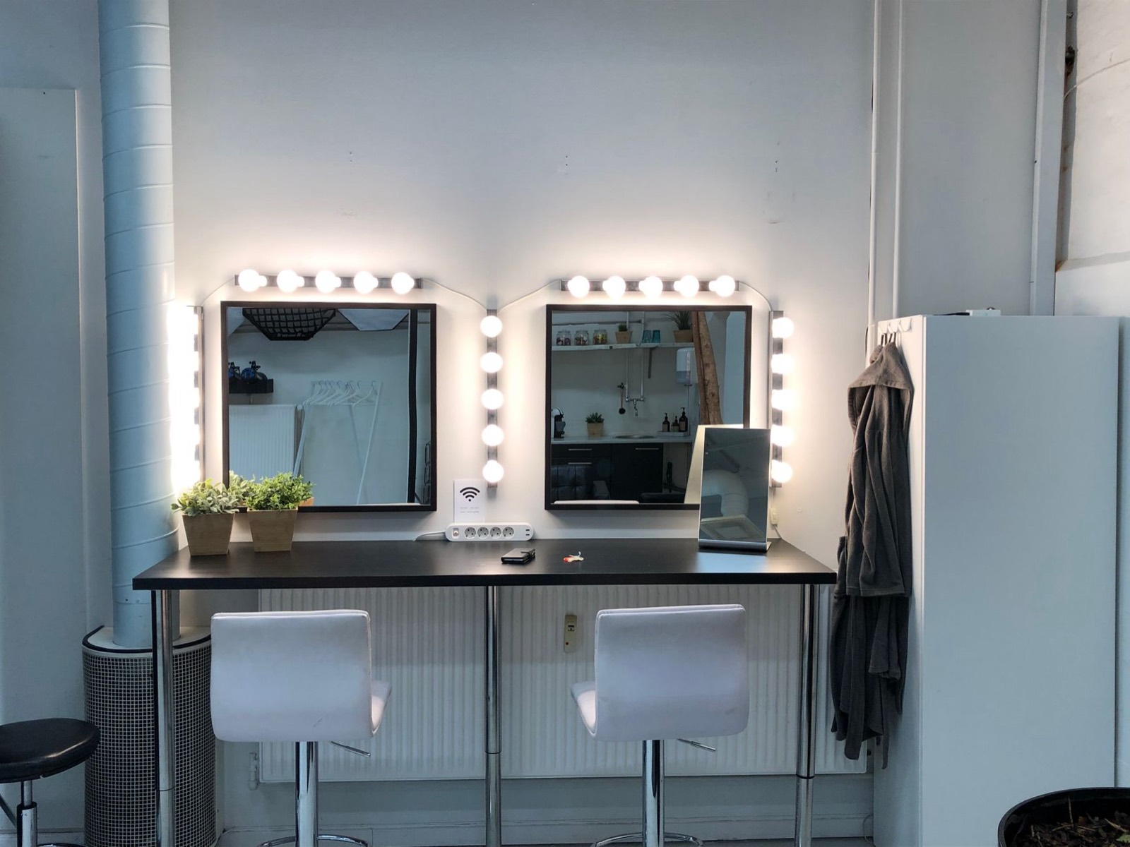 Vanity mirror surrounded by light bulbs providing even, shadow-free lighting