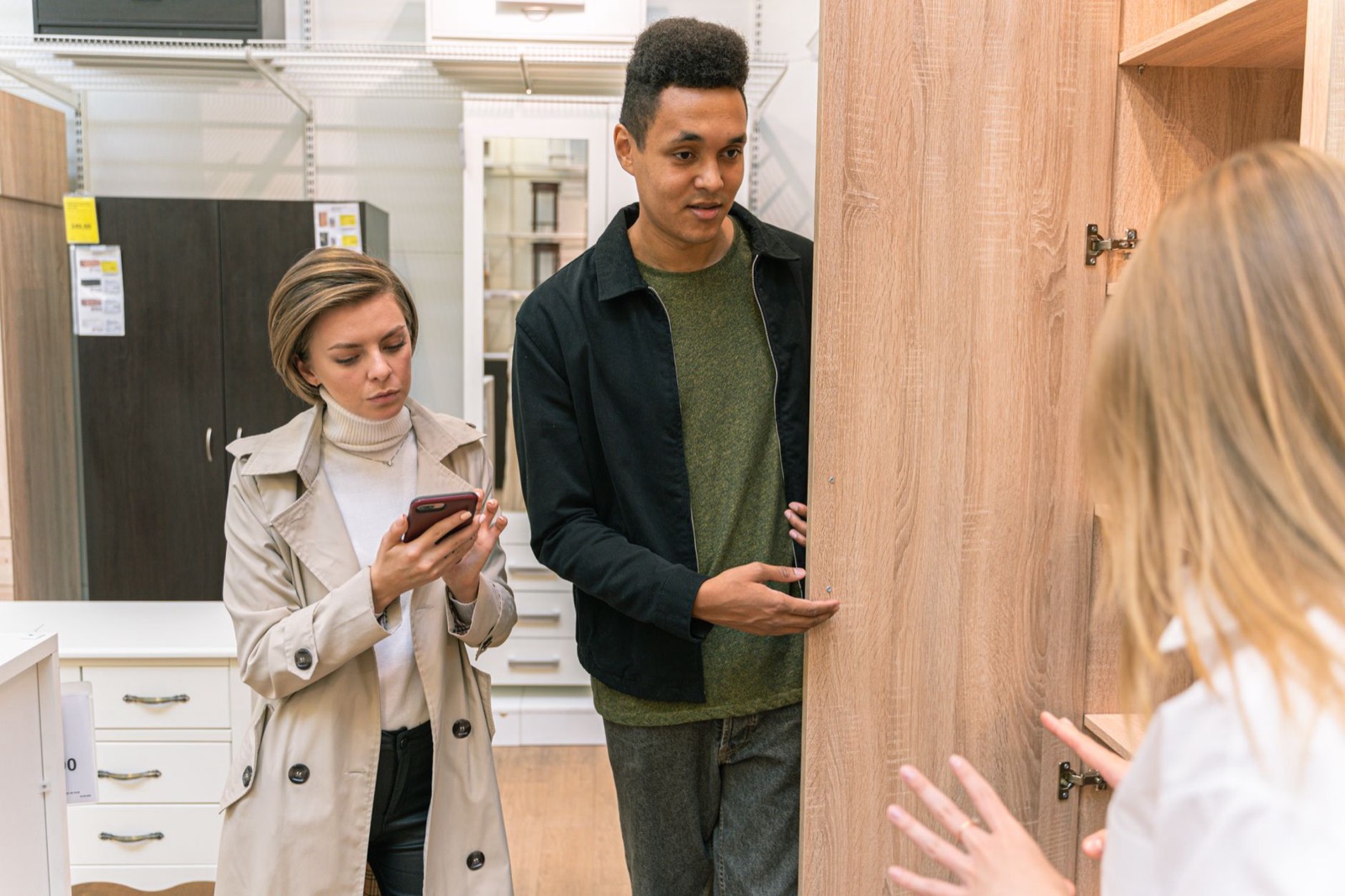 Shoppers discussing furniture payment options with a salesperson in a showroom