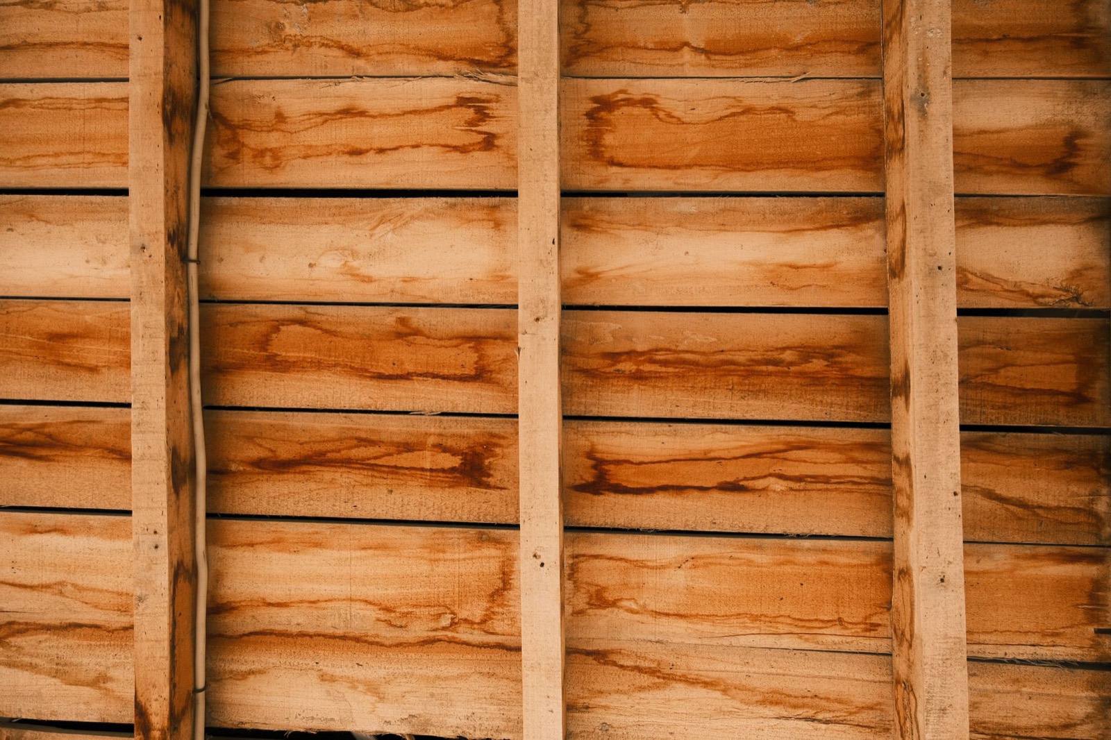 Close-up of wooden bed frame slats showing the gaps that determine whether a bunkie board is needed