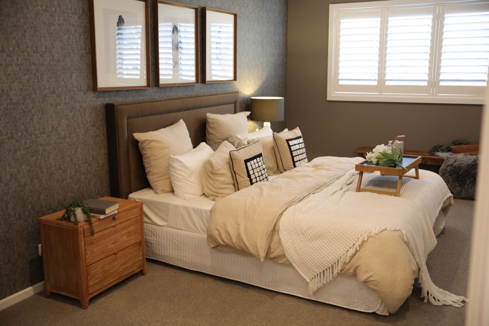 Queen bed frame in a neutral bedroom showing how a bunkie board keeps mattress height low