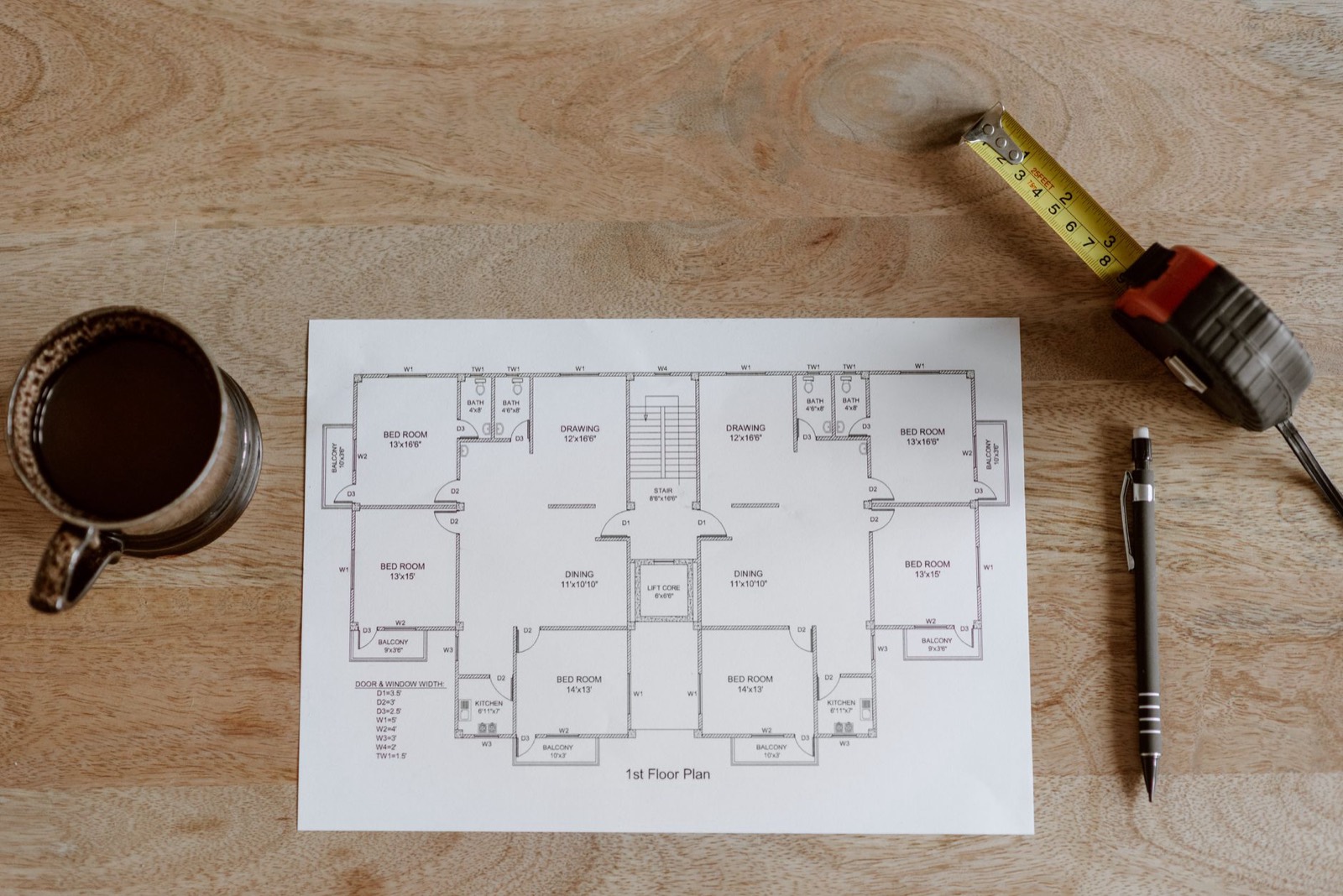 Tape measure and floor plan used to mark out a sofa footprint before buying